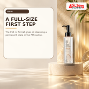 150ml cleansing oil beside a tall amber-lit architectural column.